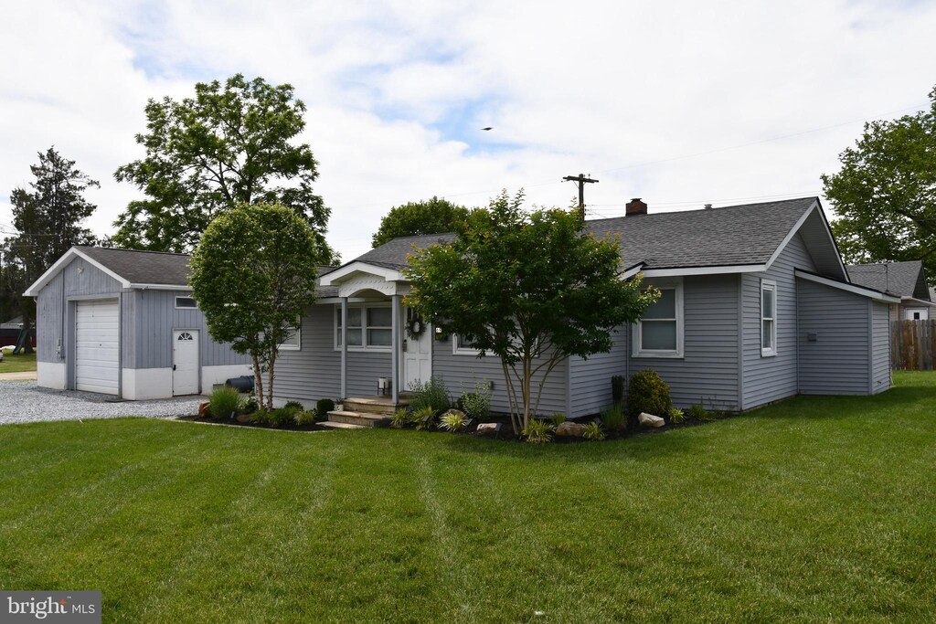 69 Walker Ave, Carneys Point, NJ 08069 - view of front facade with a shingled roof, a front yard, a chimney, and a detached garage
