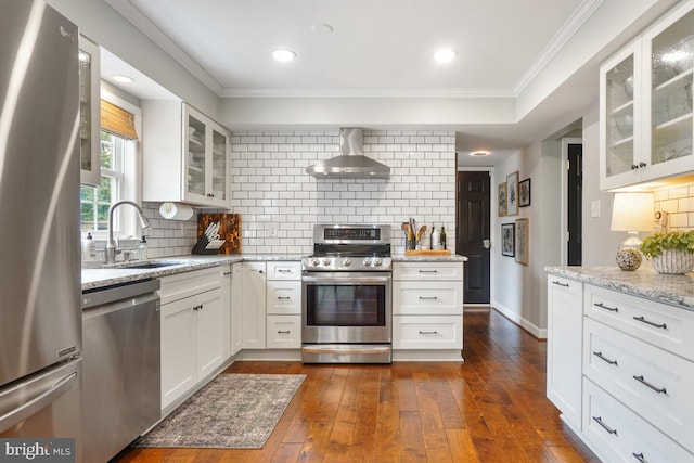 9977 Mallow Ct, Manassas, VA 20110 - kitchen featuring stainless steel appliances, wall chimney range hood, a sink, ornamental molding, and backsplash