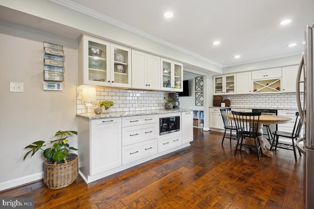 9977 Mallow Ct, Manassas, VA 20110 - kitchen featuring ornamental molding, tasteful backsplash, white cabinets, dark wood-style floors, and recessed lighting