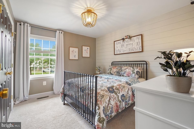 9977 Mallow Ct, Manassas, VA 20110 - bedroom with a chandelier, light colored carpet, baseboards, and wood walls