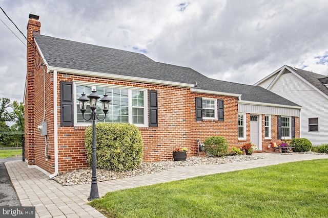 5000 Ogletown Stanton Rd, Newark, DE 19713 - view of front of home with brick siding, roof with shingles, a chimney, and a front lawn