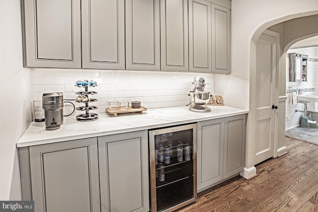 5000 Ogletown Stanton Rd, Newark, DE 19713 - bar with beverage cooler, dark wood-type flooring, arched walkways, and backsplash