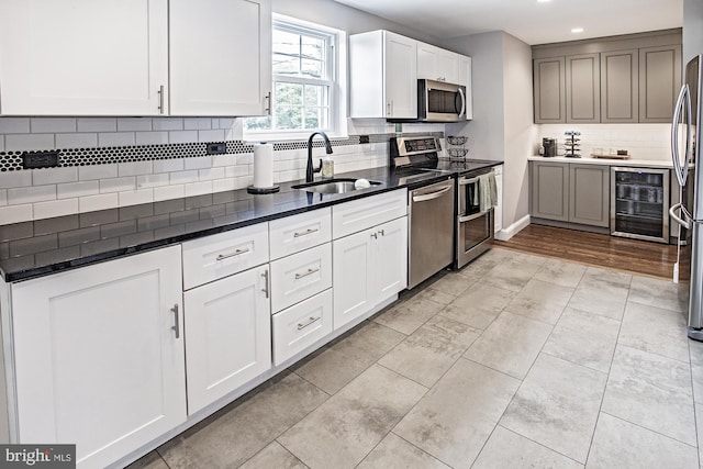 5000 Ogletown Stanton Rd, Newark, DE 19713 - kitchen featuring appliances with stainless steel finishes, beverage cooler, a sink, decorative backsplash, and recessed lighting