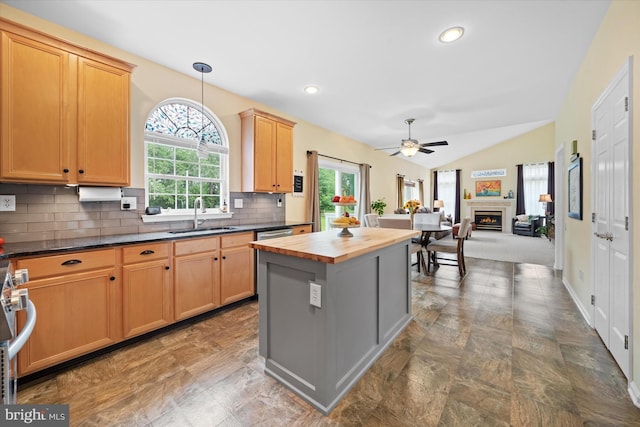 42 Manassas Dr, Middletown, DE 19709 - kitchen with butcher block countertops, a sink, a warm lit fireplace, ceiling fan, and decorative backsplash