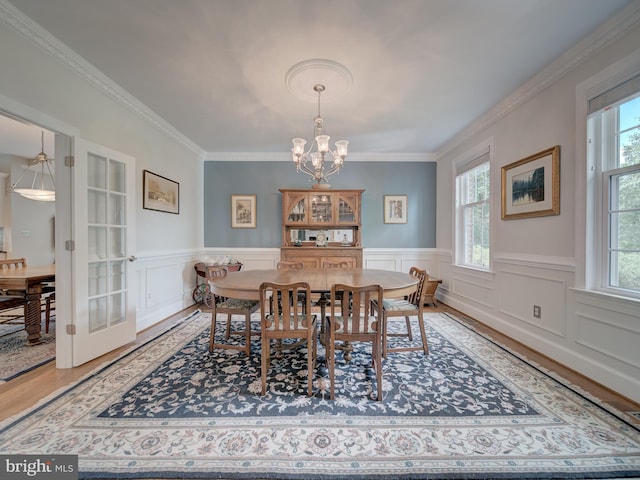 4387 Stepney Dr, Gainesville, VA 20155 - dining room featuring a chandelier, wood finished floors, crown molding, and a wainscoted wall
