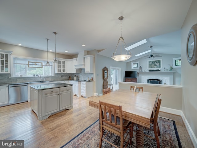4387 Stepney Dr, Gainesville, VA 20155 - dining area featuring a ceiling fan, light wood-style floors, a skylight, baseboards, and a fireplace