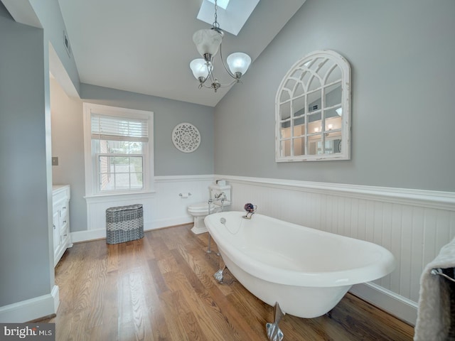 4387 Stepney Dr, Gainesville, VA 20155 - bathroom featuring a freestanding tub, a wainscoted wall, a chandelier, lofted ceiling, and a skylight