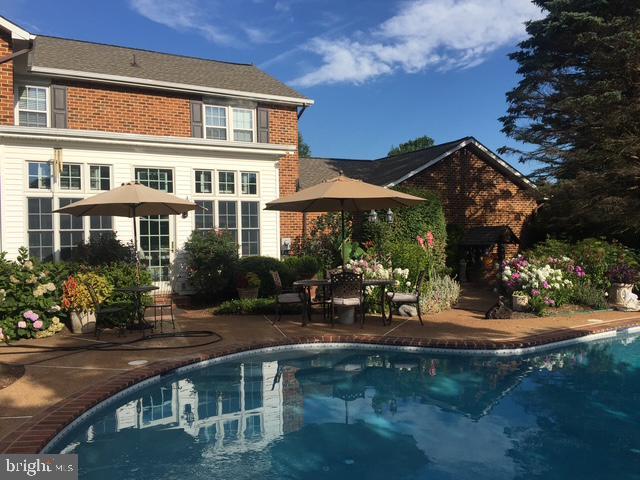 4387 Stepney Dr, Gainesville, VA 20155 - back of house featuring a patio, an outdoor pool, and brick siding