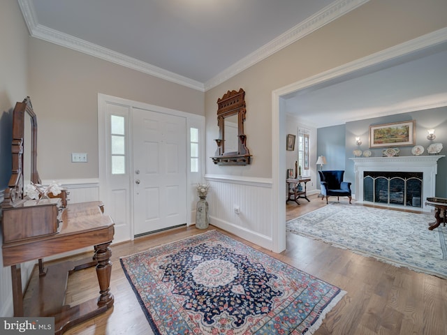 4387 Stepney Dr, Gainesville, VA 20155 - foyer entrance with crown molding, wood finished floors, a wainscoted wall, and a fireplace