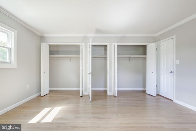 11830 Charles Rd, Silver Spring, MD 20906 - unfurnished bedroom featuring light wood-type flooring, multiple closets, crown molding, and baseboards