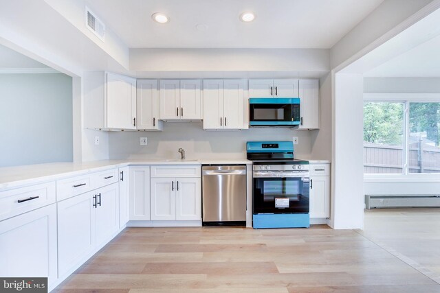 11830 Charles Rd, Silver Spring, MD 20906 - kitchen with appliances with stainless steel finishes, a baseboard radiator, white cabinets, light countertops, and recessed lighting