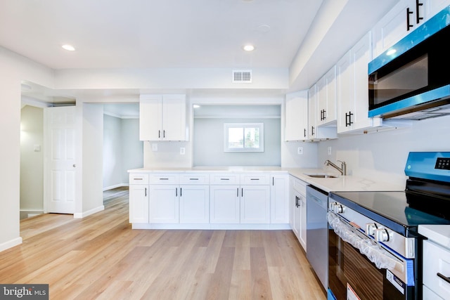 11830 Charles Rd, Silver Spring, MD 20906 - kitchen featuring appliances with stainless steel finishes, a sink, white cabinetry, light countertops, and light wood finished floors
