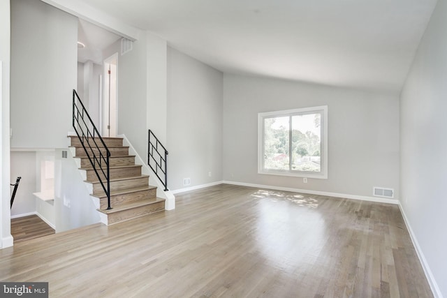 11830 Charles Rd, Silver Spring, MD 20906 - unfurnished living room with vaulted ceiling, wood finished floors, baseboards, and stairway