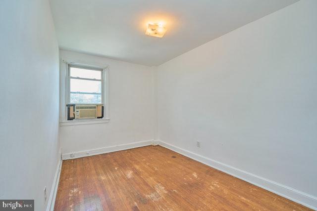 66 Allison St NE, Washington, DC 20011 - empty room featuring wood-type flooring, baseboards, and cooling unit