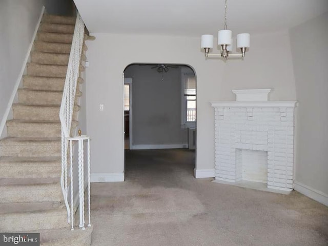 2130 Melvin St, Philadelphia, PA 19131 - unfurnished living room featuring stairway, arched walkways, carpet floors, a fireplace, and baseboards