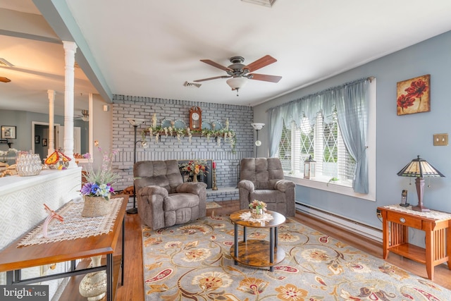 64 Sepulga Dr, Browns Mills, NJ 08015 - living room with wood finished floors, a ceiling fan, decorative columns, a fireplace, and baseboard heating