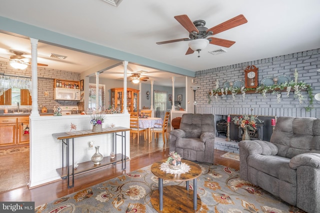 64 Sepulga Dr, Browns Mills, NJ 08015 - living room featuring brick wall, ceiling fan, healthy amount of natural light, decorative columns, and wood finished floors