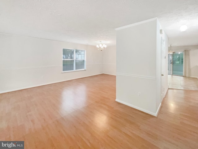 6502 Elk Ct, Waldorf, MD 20603 - spare room featuring a chandelier, wood finished floors, a textured ceiling, and baseboards