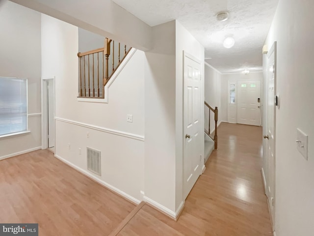 6502 Elk Ct, Waldorf, MD 20603 - hallway with wood finished floors, stairs, baseboards, and a textured ceiling