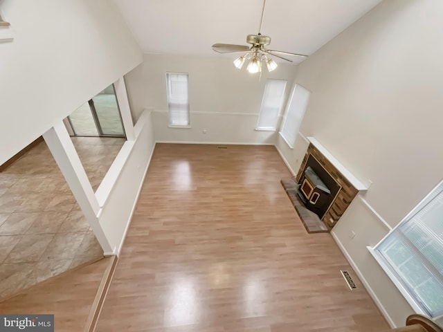 6502 Elk Ct, Waldorf, MD 20603 - unfurnished living room featuring ceiling fan, light wood-style floors, a glass covered fireplace, baseboards, and vaulted ceiling