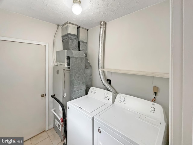 6502 Elk Ct, Waldorf, MD 20603 - washroom with washing machine and clothes dryer, light tile patterned floors, and a textured ceiling