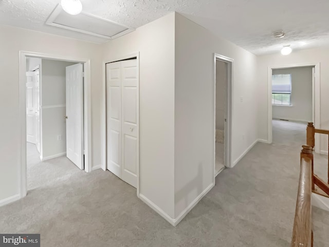 6502 Elk Ct, Waldorf, MD 20603 - hall featuring carpet, attic access, baseboards, an upstairs landing, and a textured ceiling