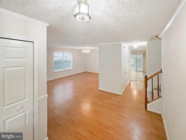 6502 Elk Ct, Waldorf, MD 20603 - unfurnished room featuring a chandelier, light wood-style flooring, a textured ceiling, ornamental molding, and baseboards