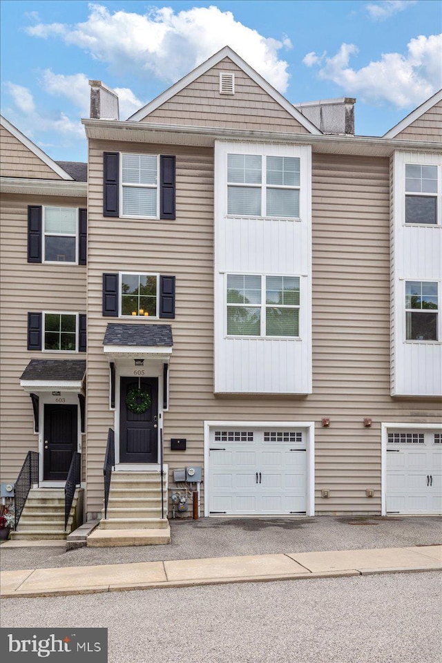 605 Apple St, Conshohocken, PA 19428 - view of property featuring an attached garage, a chimney, entry steps, and driveway