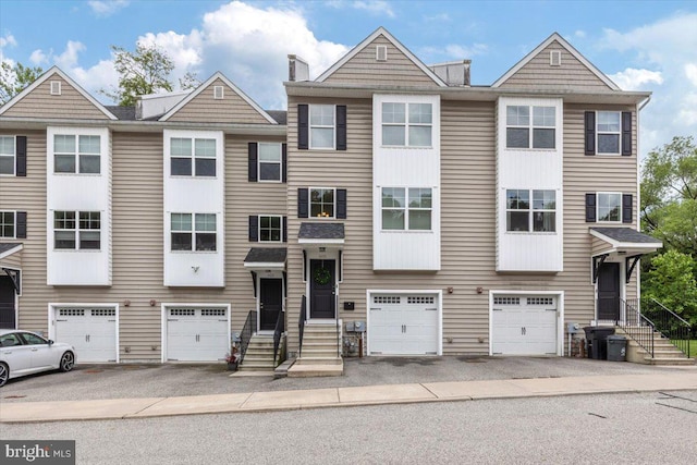 605 Apple St, Conshohocken, PA 19428 - view of property with an attached garage, driveway, a chimney, and entry steps