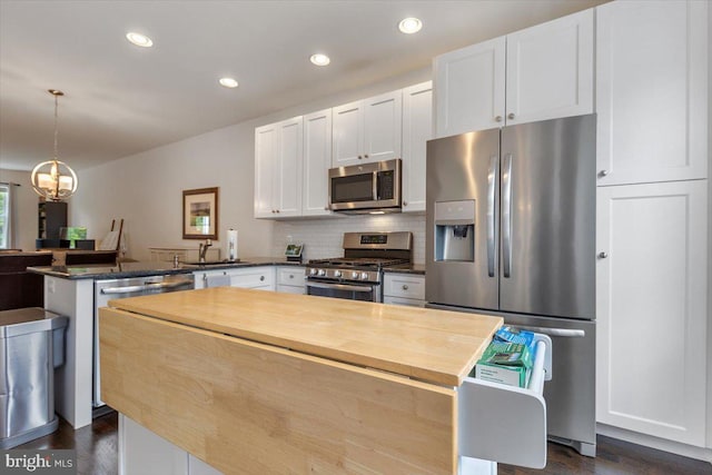 605 Apple St, Conshohocken, PA 19428 - kitchen with appliances with stainless steel finishes, a peninsula, white cabinetry, a sink, and dark wood-style flooring
