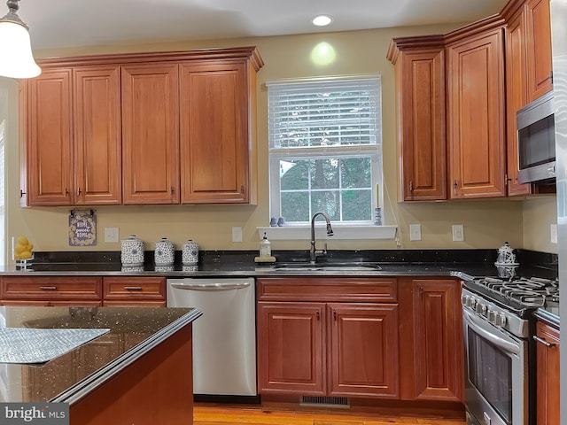 21143 Catnip Ct, Leonardtown, MD 20650 - kitchen with stainless steel appliances, a sink, dark stone countertops, brown cabinetry, and recessed lighting
