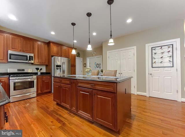 21143 Catnip Ct, Leonardtown, MD 20650 - kitchen with stainless steel appliances, dark countertops, pendant lighting, and light wood-style floors