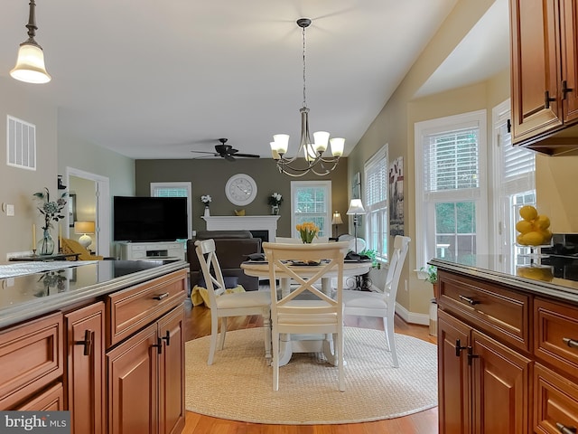 21143 Catnip Ct, Leonardtown, MD 20650 - dining area with a ceiling fan, a chandelier, light wood finished floors, a fireplace, and baseboards