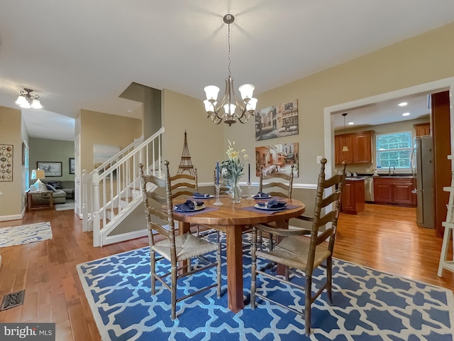 21143 Catnip Ct, Leonardtown, MD 20650 - dining area featuring light wood-style floors, a chandelier, and stairway