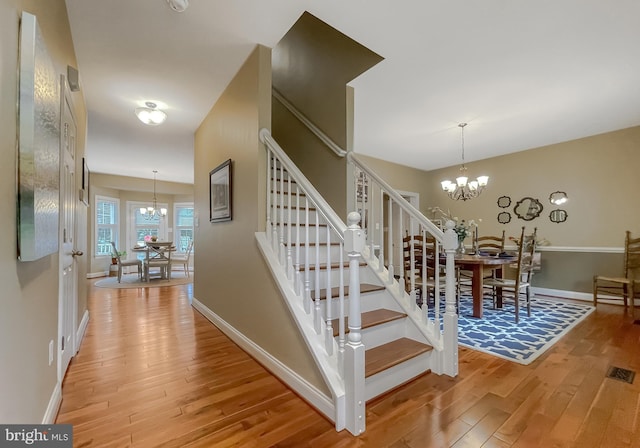 21143 Catnip Ct, Leonardtown, MD 20650 - stairs with a chandelier, wood finished floors, and baseboards