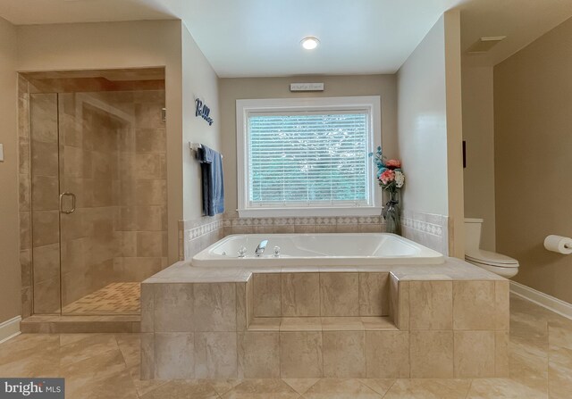 21143 Catnip Ct, Leonardtown, MD 20650 - full bathroom featuring a garden tub, a stall shower, toilet, tile patterned floors, and baseboards