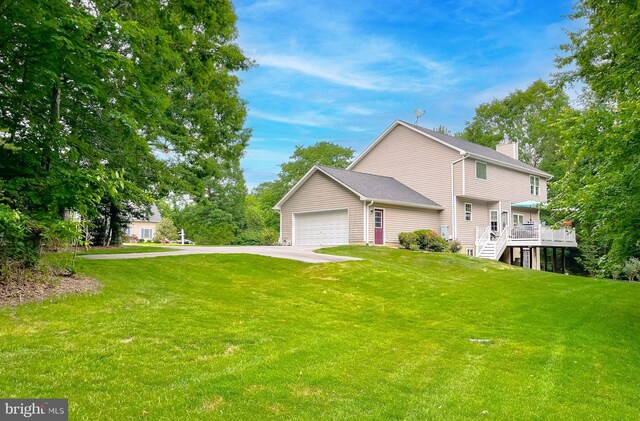 21143 Catnip Ct, Leonardtown, MD 20650 - view of side of home featuring concrete driveway, a chimney, an attached garage, stairs, and a lawn