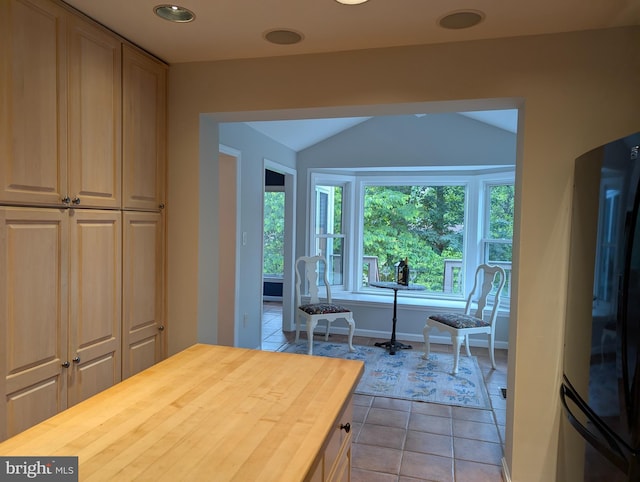 9510 Clement Rd, Silver Spring, MD 20910 - kitchen with freestanding refrigerator, wood counters, lofted ceiling, light tile patterned flooring, and baseboards
