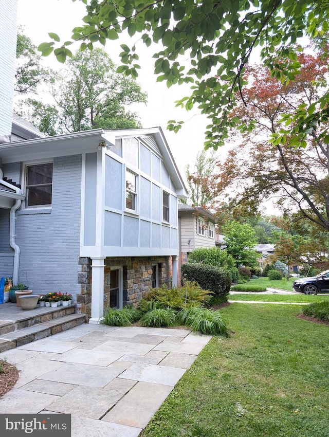 9510 Clement Rd, Silver Spring, MD 20910 - view of side of property featuring stone siding, a lawn, a patio, and brick siding