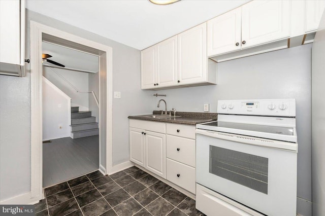 15 Degrange St, Frederick, MD 21701 - kitchen featuring white electric range, a sink, white cabinets, dark countertops, and baseboards