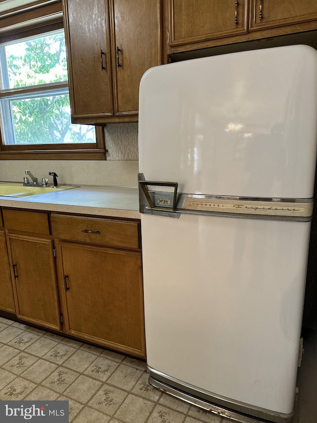 120 Lindsey Ave, Runnemede, NJ 08078 - kitchen with freestanding refrigerator, light countertops, a sink, and brown cabinets