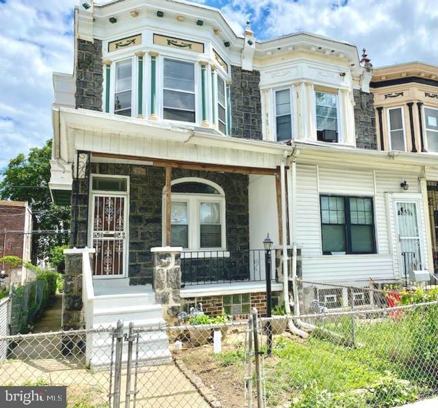 1364 Park Blvd, Camden, NJ 08103 - townhome / multi-family property featuring a porch, stone siding, a gate, and a fenced front yard