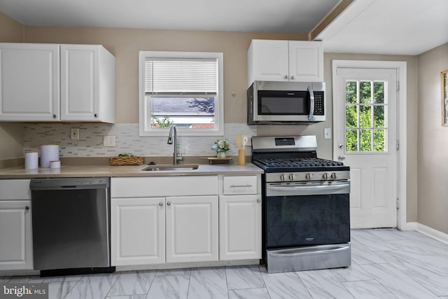5421 Omaha Ave, Baltimore, MD 21206 - kitchen featuring appliances with stainless steel finishes, a sink, white cabinetry, light marble finish floors, and light countertops