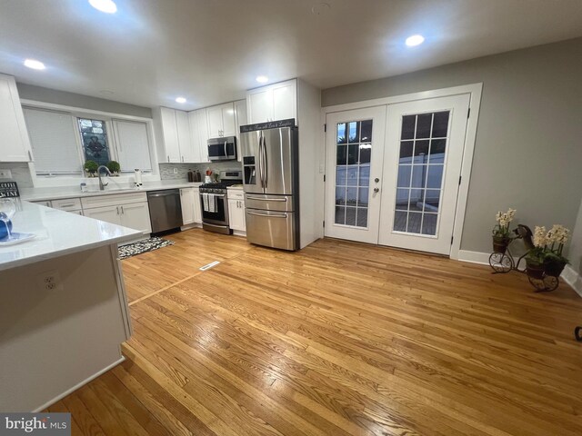 3701 Lochearn Dr, Gwynn Oak, MD 21207 - kitchen with appliances with stainless steel finishes, french doors, light wood-style flooring, a sink, and light countertops