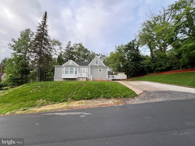 3701 Lochearn Dr, Gwynn Oak, MD 21207 - view of front of home with concrete driveway, a front yard, and view of scattered trees