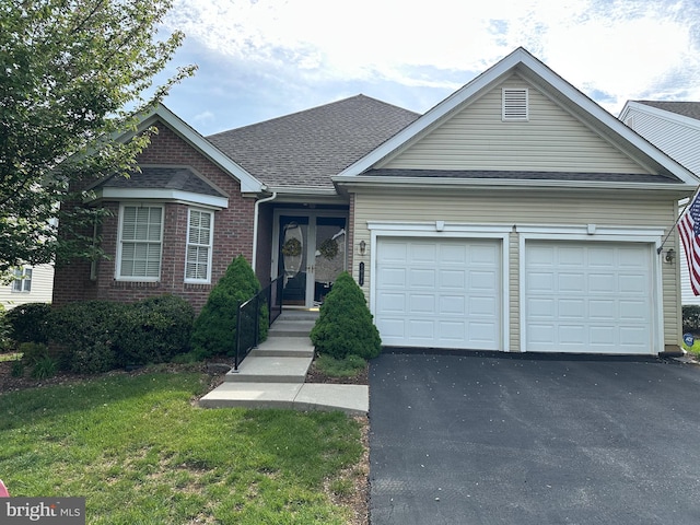 5054 Valley Stream Ln, Macungie, PA 18062 - view of front facade with an attached garage, asphalt driveway, a front yard, brick siding, and roof with shingles