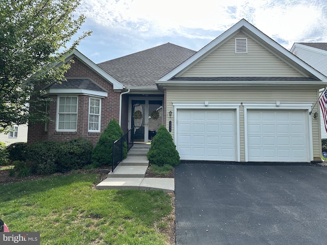 5054 Valley Stream Ln, Macungie, PA 18062 - view of front of home featuring a garage, driveway, a front lawn, brick siding, and a shingled roof