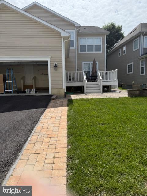 2307 Brooke Grove Rd, Bowie, MD 20721 - rear view of house with a garage, a lawn, driveway, and a wooden deck