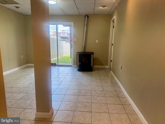 3627 Longridge Ct, Abingdon, MD 21009 - spare room featuring a paneled ceiling, a wood stove, baseboards, and light tile patterned floors