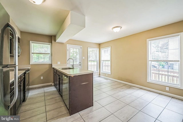 216 Parker Ave, Philadelphia, PA 19128 - kitchen featuring a peninsula, appliances with stainless steel finishes, light tile patterned flooring, a sink, and light countertops